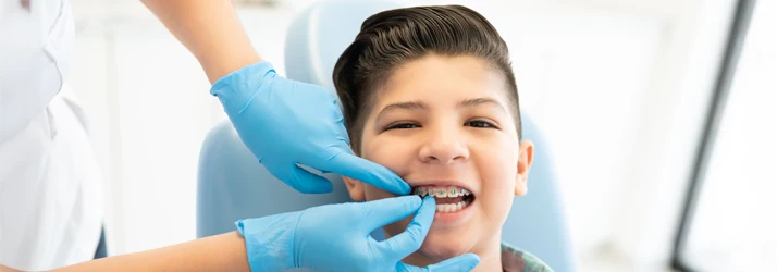 Orthodontist Ellicott City MD Young Boy With Braces A young boy getting his braces checked.