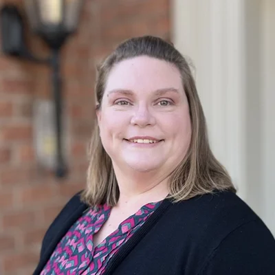 Michelle Stillman smiling in front of a brick wall.