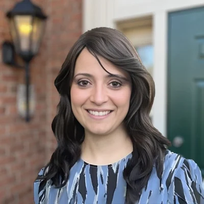 Dr. Pardis Parizadeh smiling in front of a brick wall.
